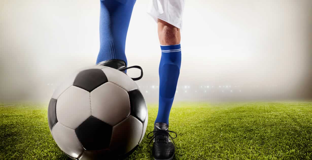 Athlete kicking soccer ball